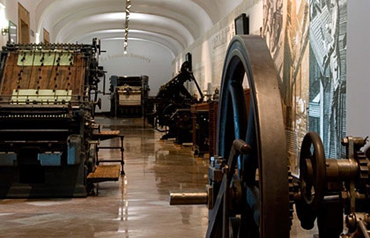 Sala de museo con antiguas máquinas de imprenta industriales del siglo XIX en exposición
