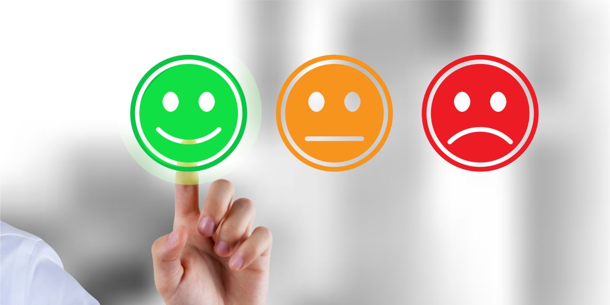 Mano señalando emoji verde feliz en encuesta de satisfacción con tres opciones de valoración